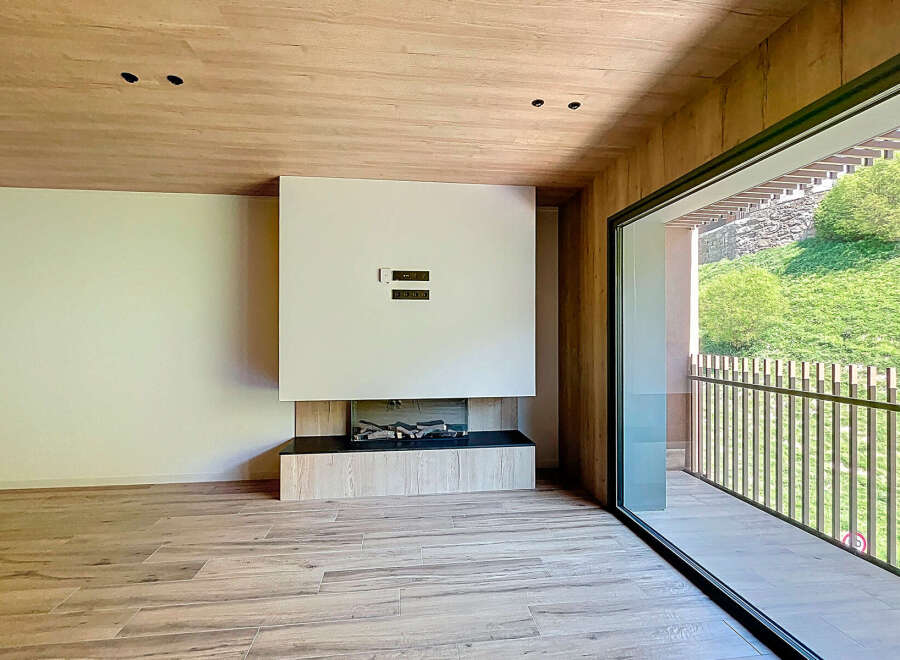 Modern living space featuring a sleek fireplace and expansive windows offering scenic views.
