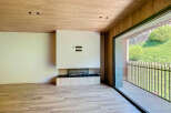 Modern living space featuring a sleek fireplace and expansive windows offering scenic views.