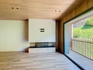 Modern living space featuring a sleek fireplace and expansive windows offering scenic views.