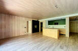 Stunning open-plan living space with light wood flooring and walls, creating a warm and inviting atmosphere.