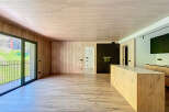 Stunning open-plan living space with wood flooring and walls, creating a warm and inviting atmosphere.
