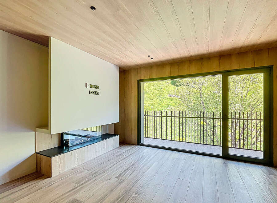 Modern living space with a built-in fireplace and large windows offering scenic views.