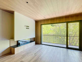 Modern living space with a built-in fireplace and large windows offering scenic views.