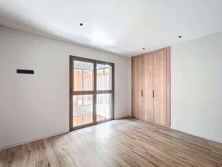This stunning property boasts a spacious bedroom with ample natural light from a large window.
