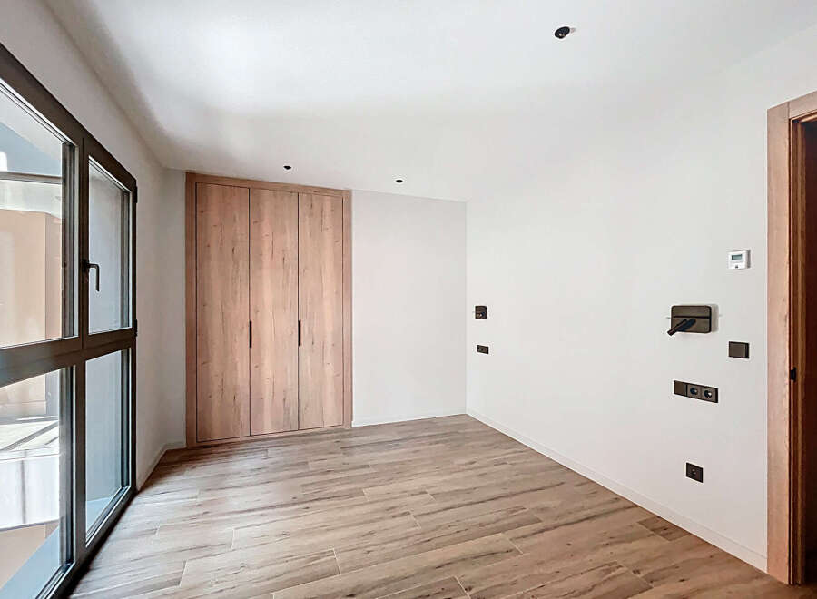 This stunning property boasts a modern, minimalist design with light wood flooring and built-in wardrobes.