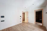 This stunning property boasts a spacious, bright interior with sleek wooden flooring and modern light fixtures.