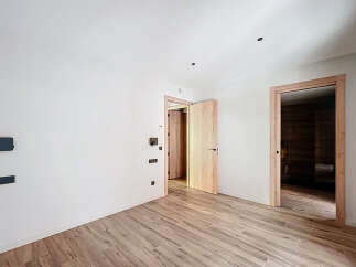This stunning property boasts a spacious, bright interior with sleek wooden flooring and modern light fixtures.