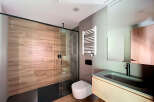 Modern bathroom with a walk-in shower, sleek sink vanity, and heated towel rack.