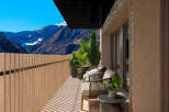 Luxury mountain view balcony with wooden fence and modern furniture.