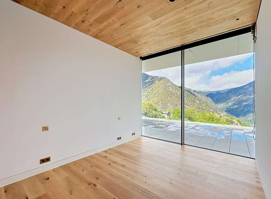 Experience breathtaking views from this modern property featuring expansive windows that frame the stunning mountain landscape.