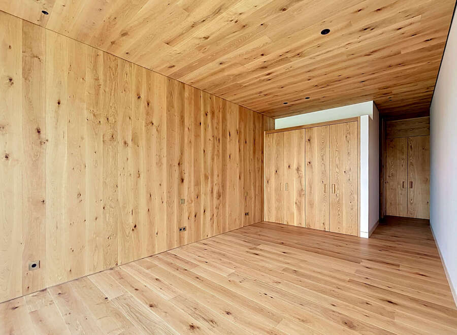 This stunning property boasts a warm and inviting interior, featuring exquisite wooden walls, ceilings, and flooring.