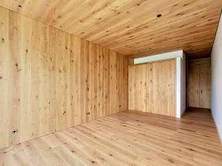 This stunning property boasts a warm and inviting interior, featuring exquisite wooden walls, ceilings, and flooring.