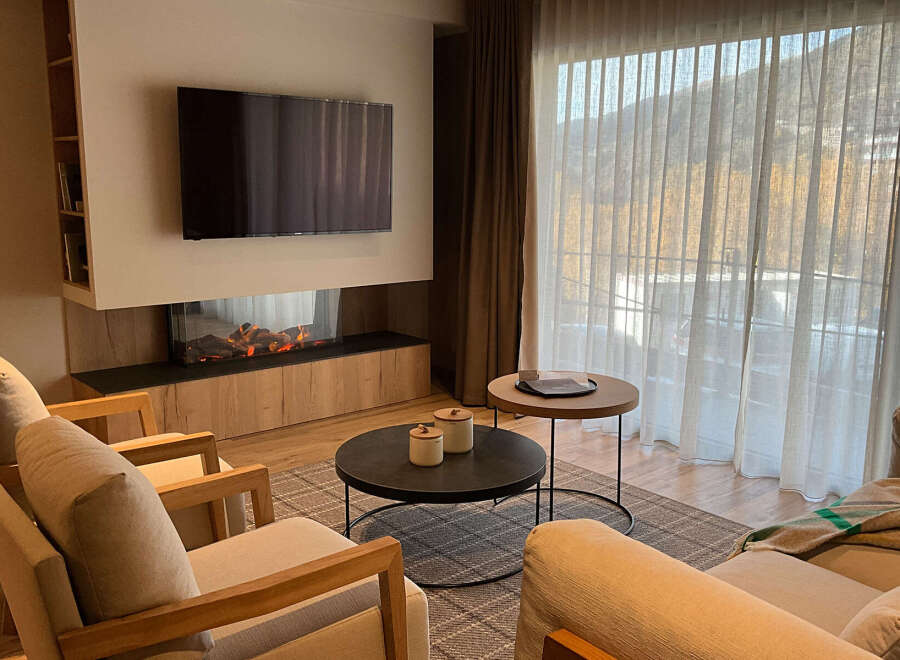 Experience luxury living in this stunning property, featuring a modern fireplace and a sleek TV setup, perfect for cozy evenings.
