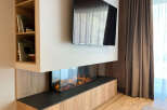 This modern living space features a sleek fireplace and a mounted television, creating a cozy and stylish ambiance.