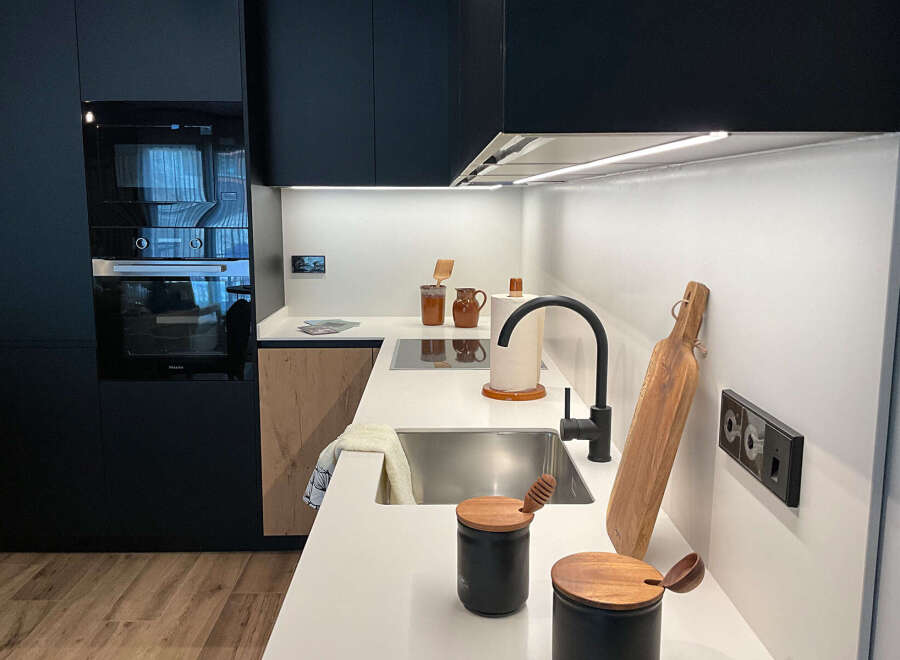 Discover modern living in this stylish kitchen! Featuring sleek black cabinetry, a stainless steel sink, and a contemporary faucet, this space is designed for both functionality and elegance.