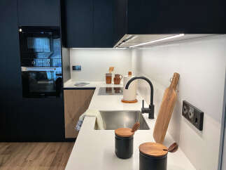 Discover modern living in this stylish kitchen! Featuring sleek black cabinetry, a stainless steel sink, and a contemporary faucet, this space is designed for both functionality and elegance.