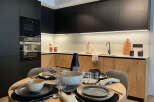 This modern kitchen boasts sleek black cabinetry and warm wood accents, creating a stylish and inviting space.