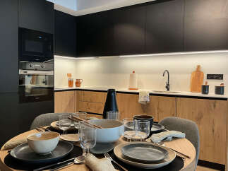 This modern kitchen boasts sleek black cabinetry and warm wood accents, creating a stylish and inviting space.