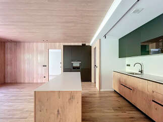 This stunning kitchen boasts a modern design with sleek dark cabinetry and light wood countertops and flooring.