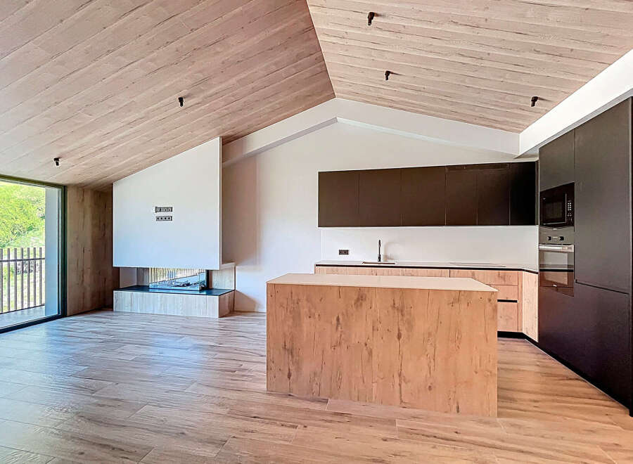 This stunning modern kitchen boasts a sleek design with a wooden island and cabinetry.