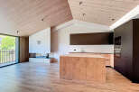 This stunning modern kitchen boasts a sleek design with a wooden island and cabinetry.