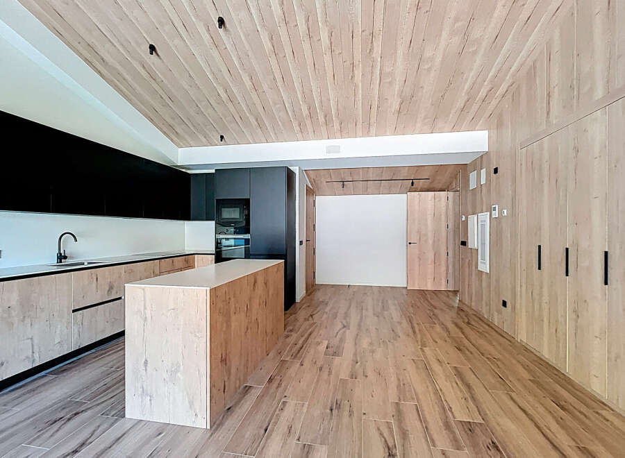 This modern kitchen boasts a sleek design with wooden accents, creating a warm and inviting atmosphere.