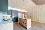 This modern kitchen boasts a sleek design with a wooden ceiling and walls, creating a warm and inviting atmosphere.