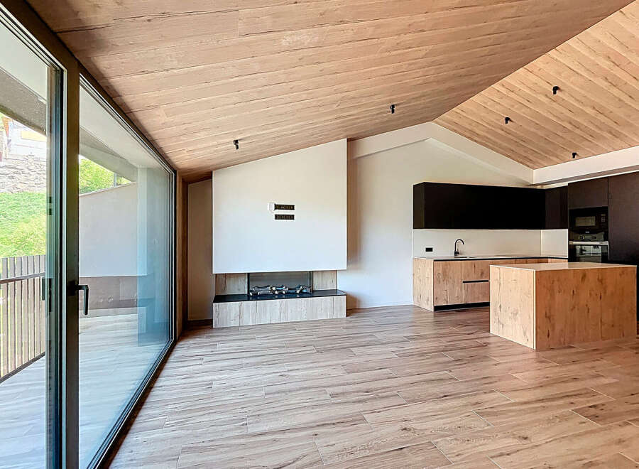 This stunning modern home features a spacious open-plan living area with a sleek kitchen and a cozy fireplace.