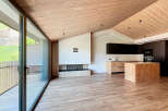 This stunning modern home features a spacious open-plan living area with a sleek kitchen and a cozy fireplace.