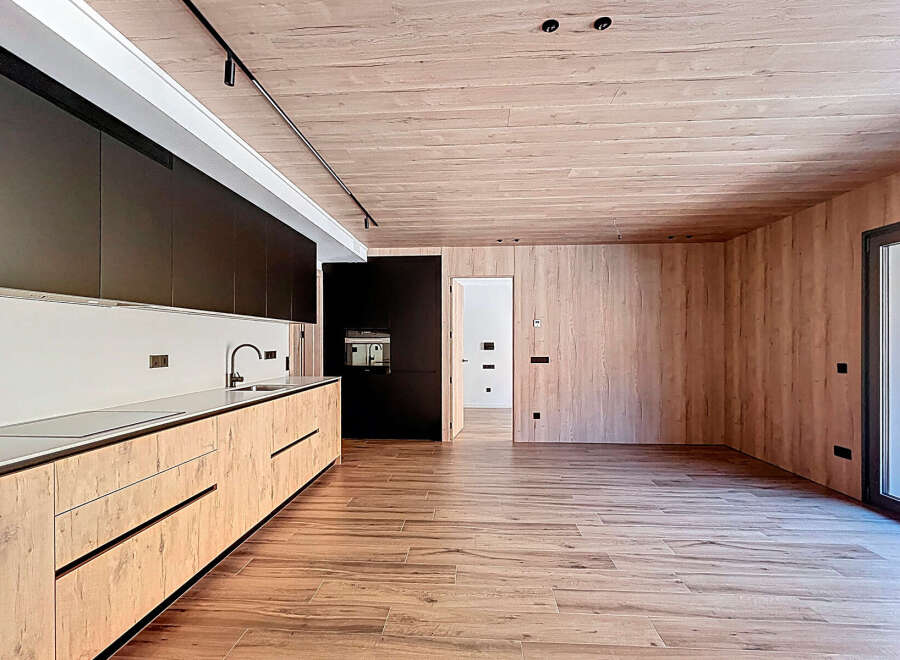 This modern kitchen boasts a sleek design with wooden cabinetry and a minimalist aesthetic.
