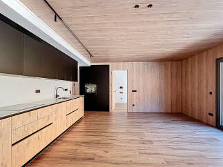 This modern kitchen boasts a sleek design with wooden cabinetry and a minimalist aesthetic.