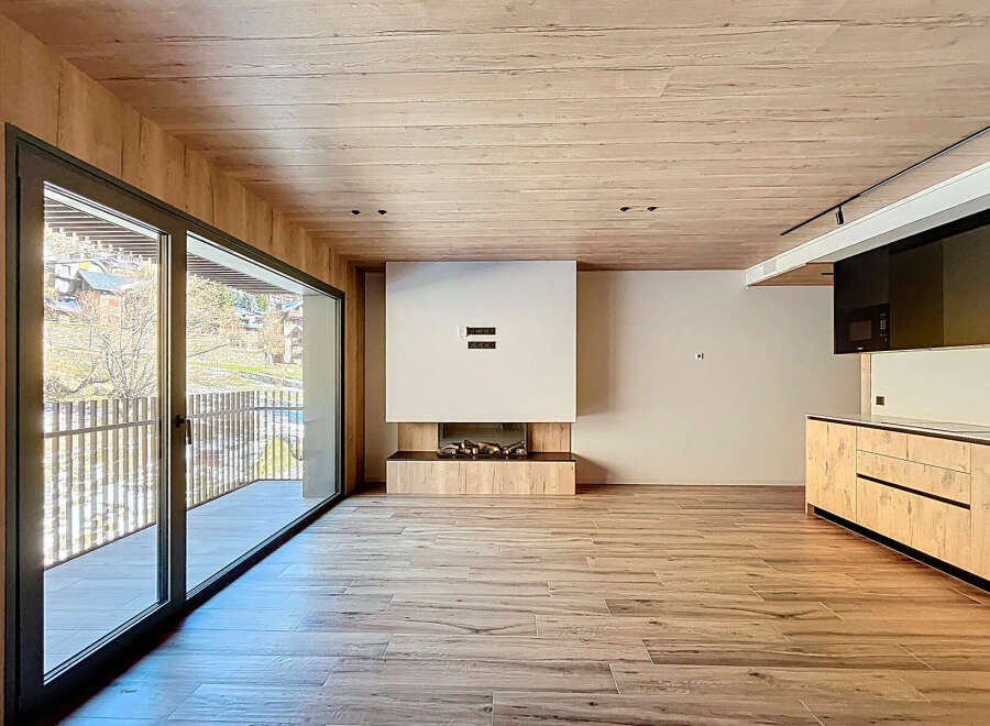 Experience luxury living in this stunning property featuring a modern fireplace and a sleek kitchen design.
