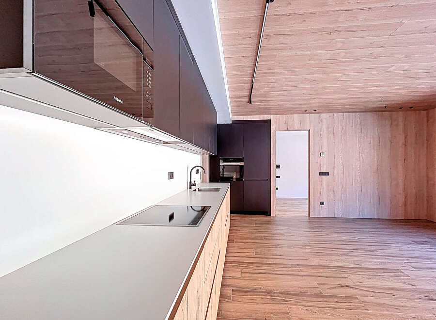 This modern kitchen boasts sleek, dark cabinetry and a minimalist design.