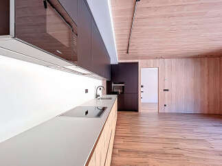 This modern kitchen boasts sleek, dark cabinetry and a minimalist design.