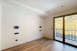Discover the elegance of this modern interior, featuring pristine white walls and warm wooden flooring.
