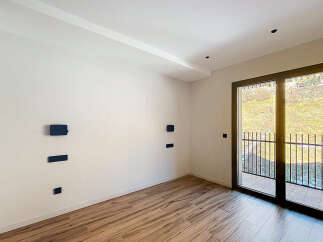 Discover the elegance of this modern interior, featuring pristine white walls and warm wooden flooring.