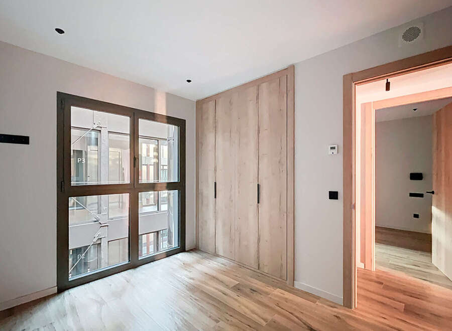 Discover modern living in this stylish property, featuring a spacious room with a large window that offers ample natural light.