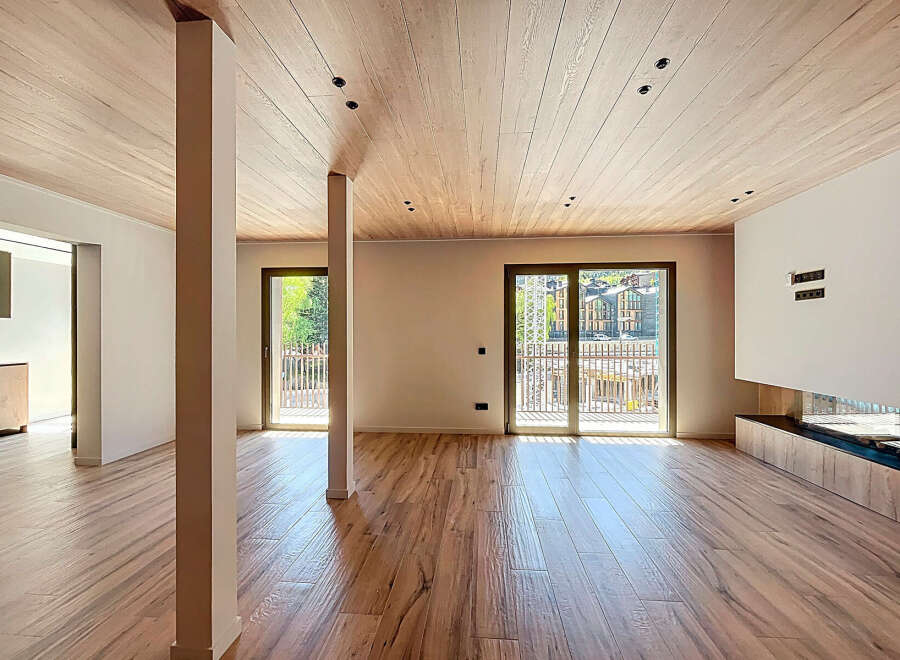 Experience modern elegance in this stunning property, featuring a spacious open-plan living area with beautiful wooden flooring and a matching ceiling.
