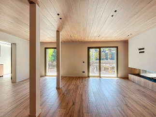 Experience modern elegance in this stunning property, featuring a spacious open-plan living area with beautiful wooden flooring and a matching ceiling.