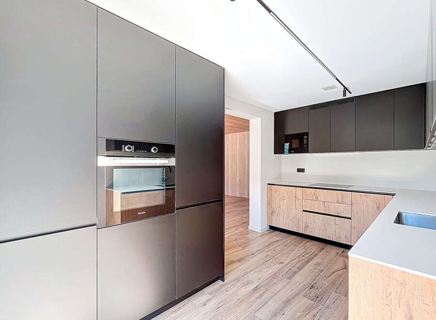 This modern kitchen boasts sleek, minimalist design with high-end appliances and ample storage.