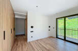 This modern bedroom boasts a sleek design with wooden flooring and a spacious wardrobe.