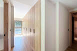 Discover the elegance of this modern home, featuring stunning wooden accents and a bright, airy hallway.