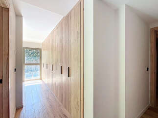 Discover the elegance of this modern home, featuring stunning wooden accents and a bright, airy hallway.