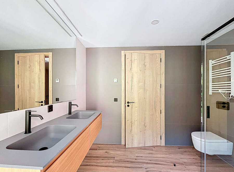 This modern bathroom boasts a sleek design with a double vanity featuring a minimalist aesthetic.