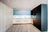 Modern kitchen with sleek dark cabinetry and light wood countertops.