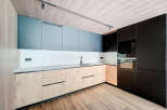 Modern kitchen with sleek gray and wood cabinets, integrated appliances, and a stylish wood-look floor.