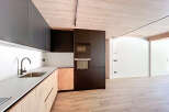 Modern kitchen with sleek dark cabinets and light wood accents.