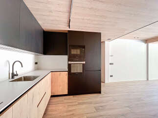 Modern kitchen with sleek dark cabinets and light wood accents.