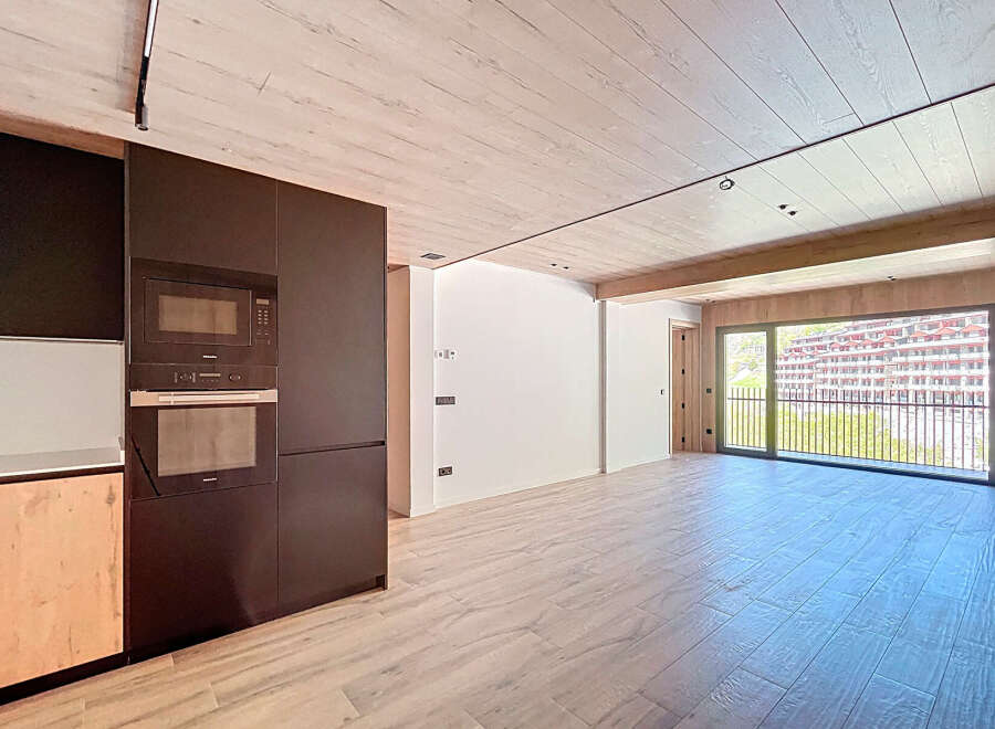 Stunning apartment boasting a modern kitchen with built-in appliances and sleek dark cabinetry.