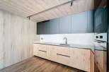 Modern kitchen with sleek gray upper cabinets and light wood lower cabinets.